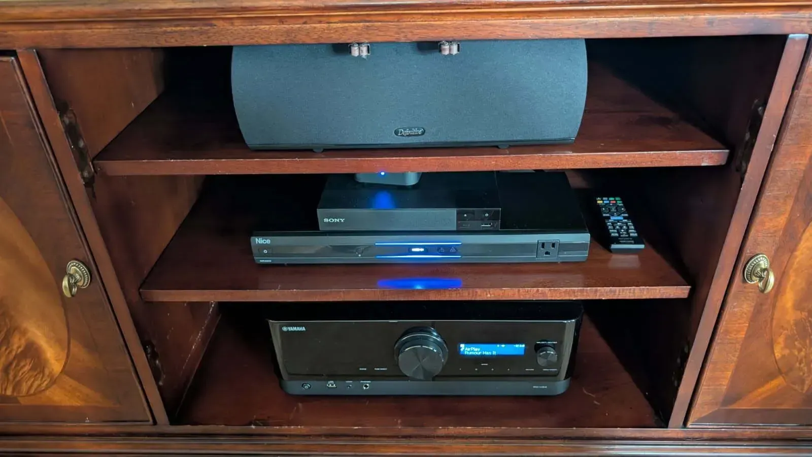 A house with a thatched roof and a blue chair under it.