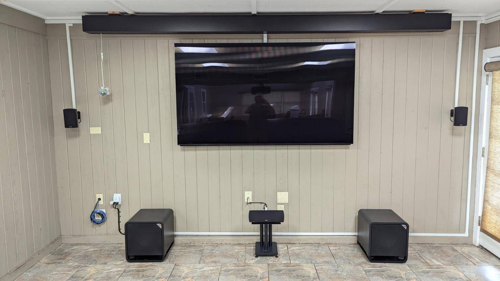 A living room with a flat screen tv and speakers