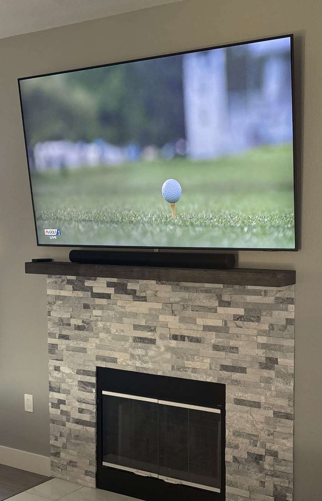 A flat screen tv is mounted above a fireplace in a living room.