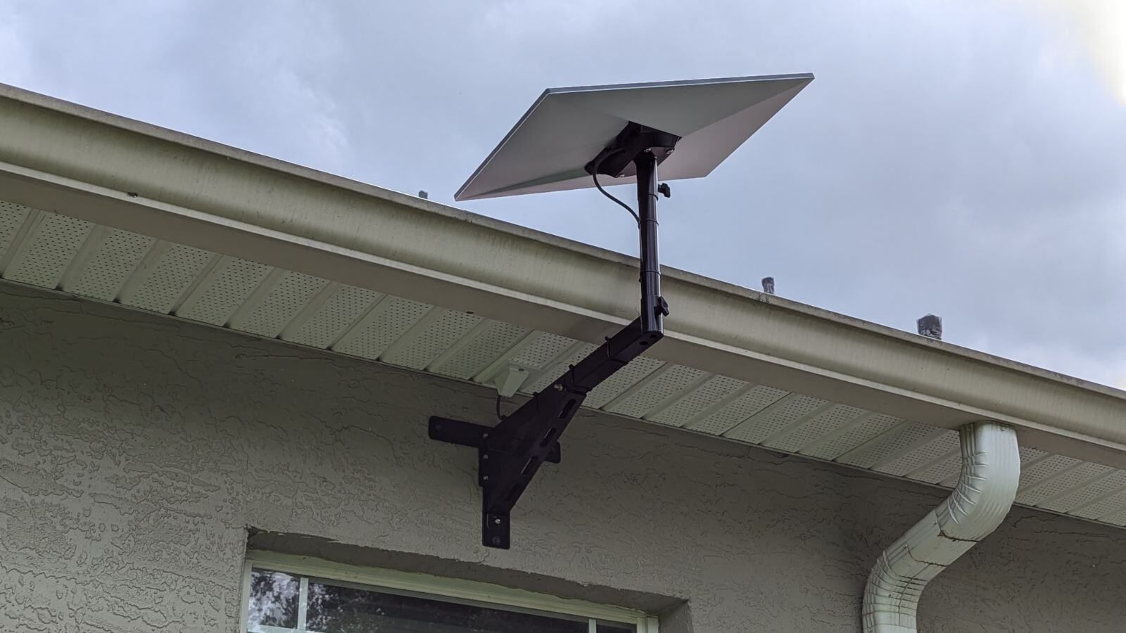 A satellite dish is mounted on the roof of a house.