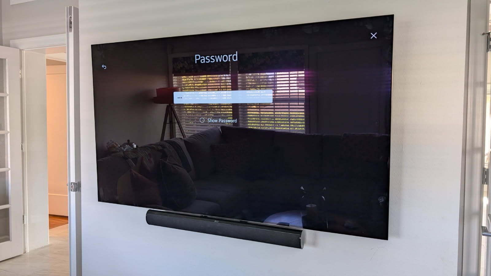 A large flat screen tv is mounted on a wall in a living room.