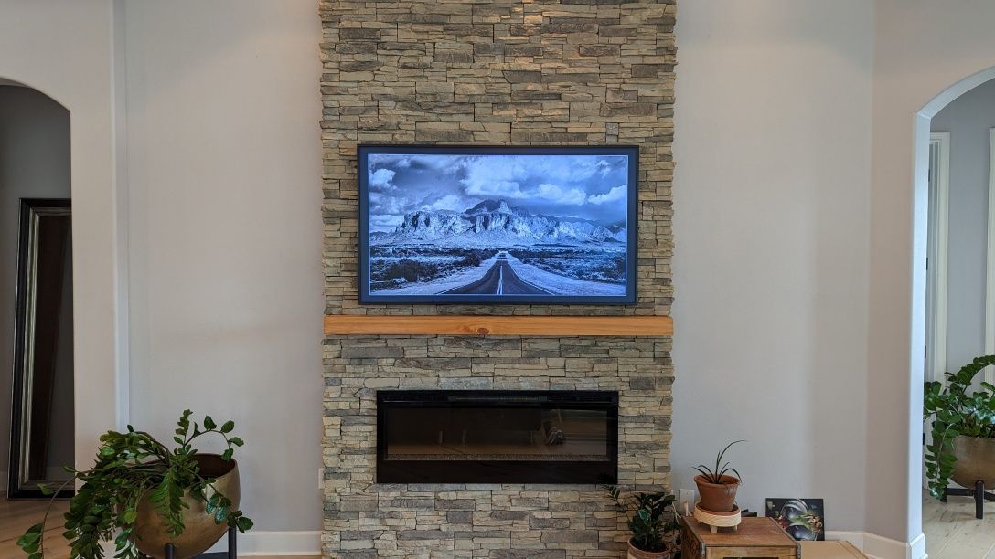 A living room with a fireplace and a flat screen tv mounted on the wall.