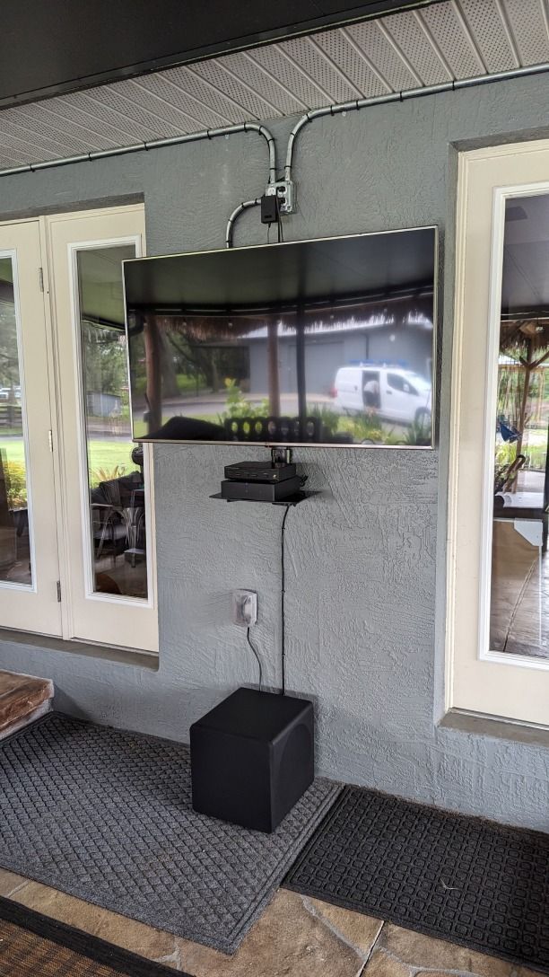 A flat screen tv is mounted on a wall in a living room.