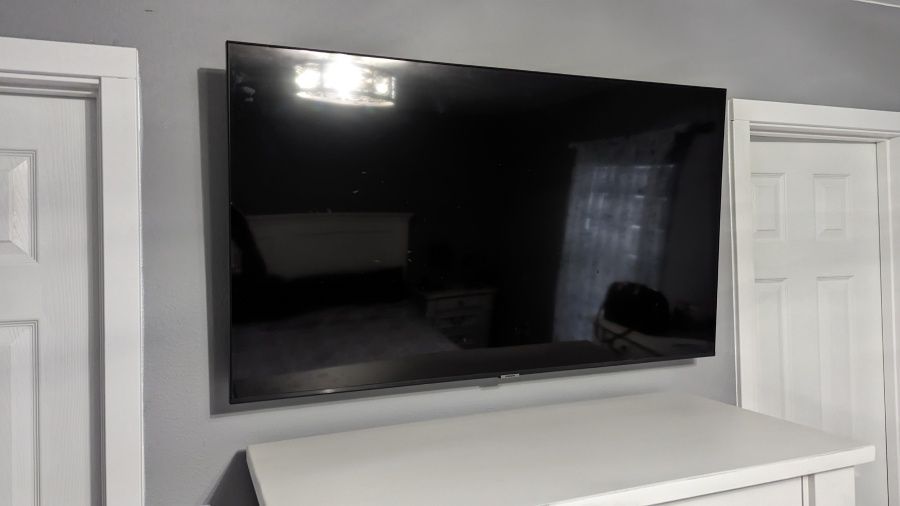 A flat screen tv is mounted on a wall in a room.
