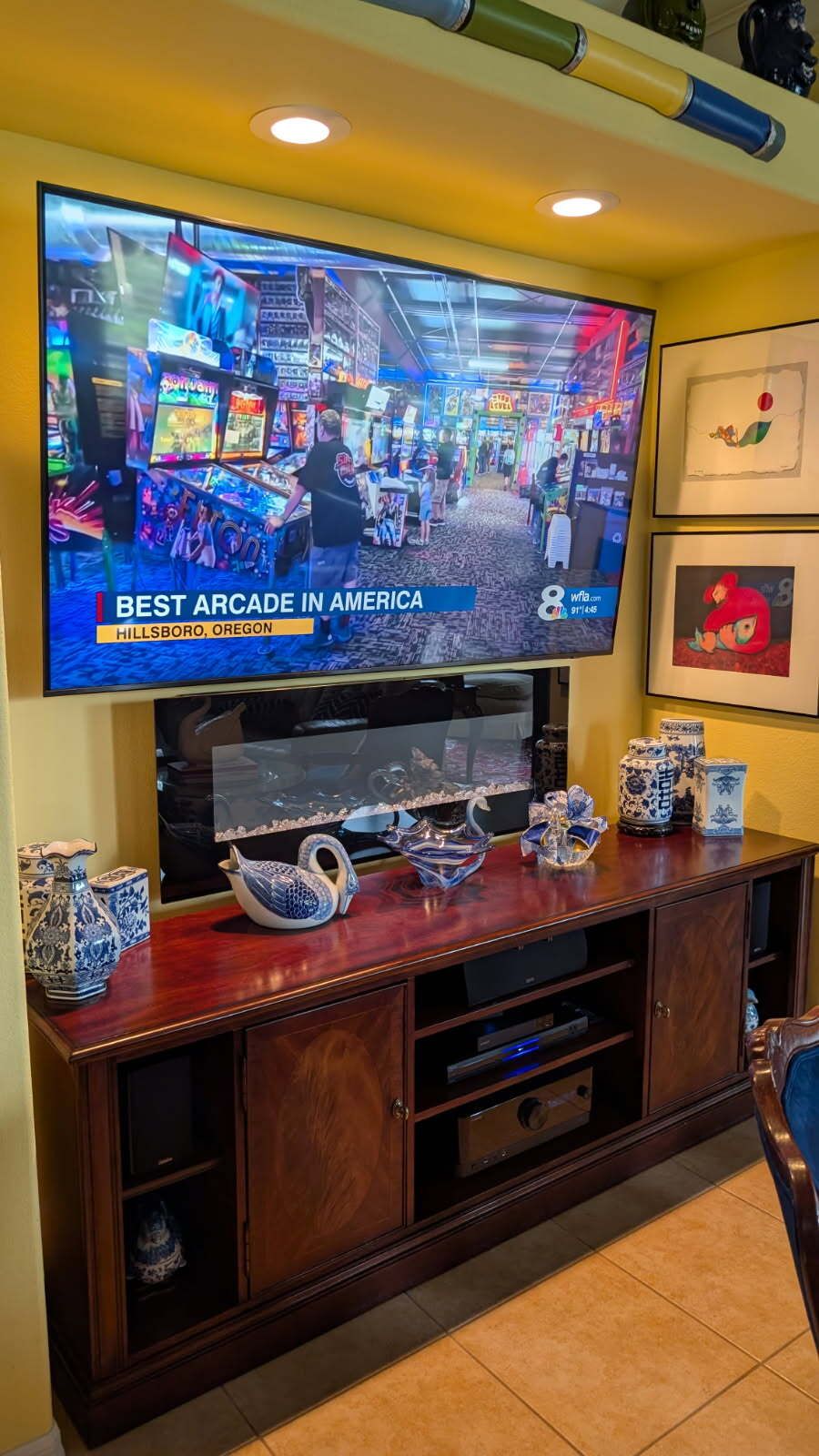 A flat screen tv is mounted on a wall above a entertainment center