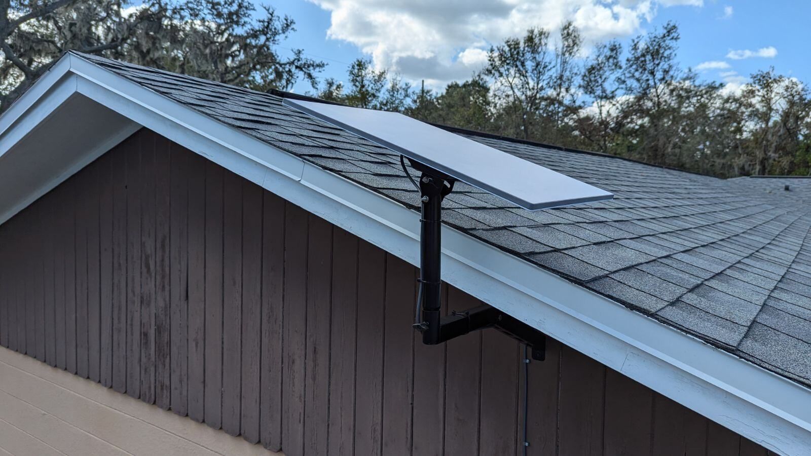 A solar panel is mounted on the roof of a house