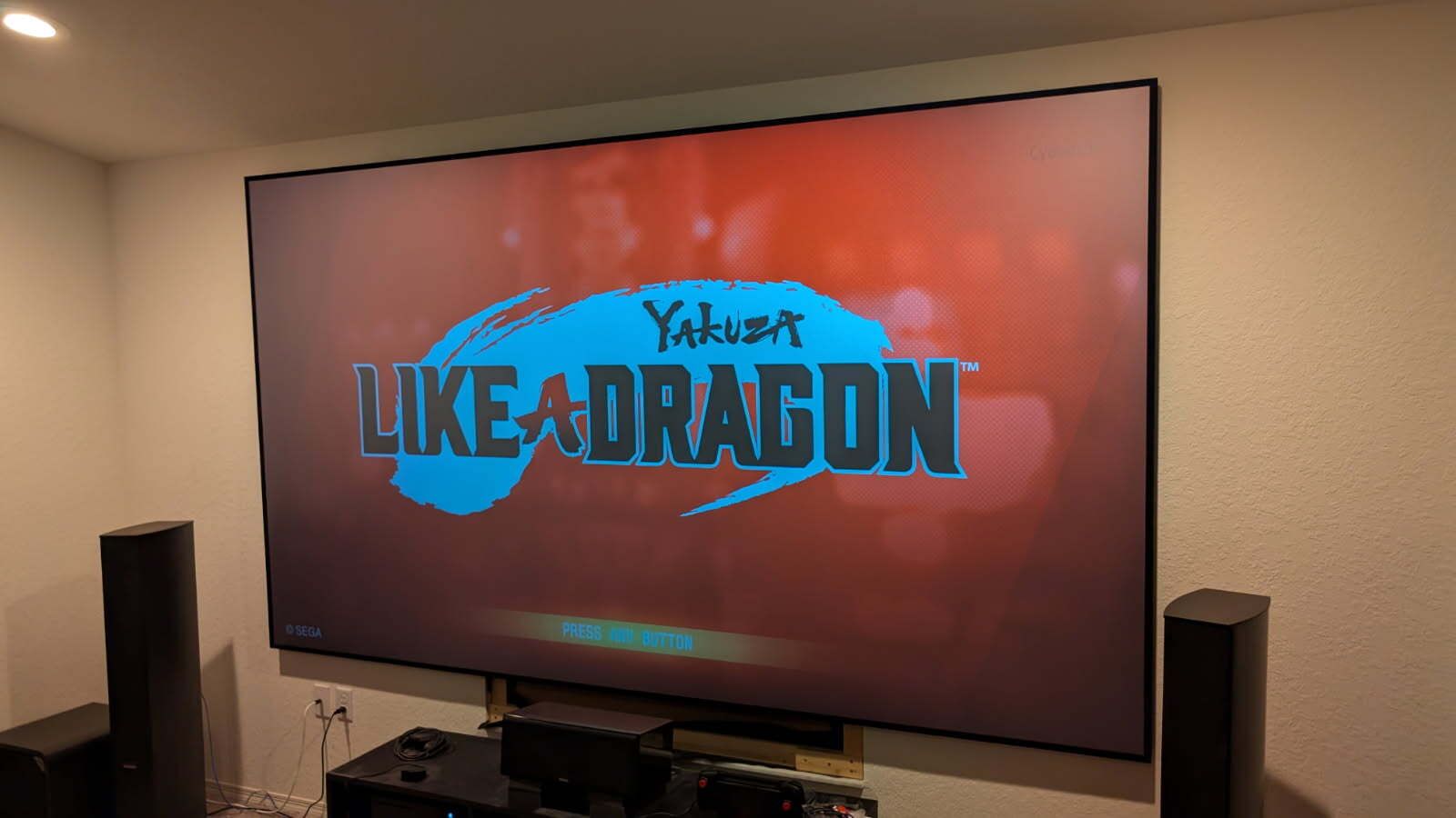 A large flat screen tv is displaying a movie called like a dragon.