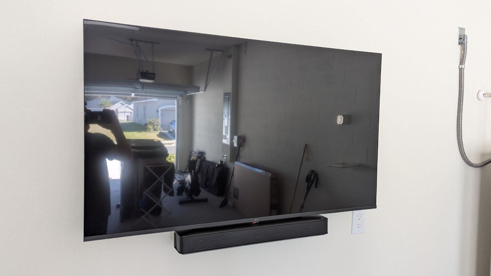 A flat screen tv is mounted on a wall next to a sound bar.