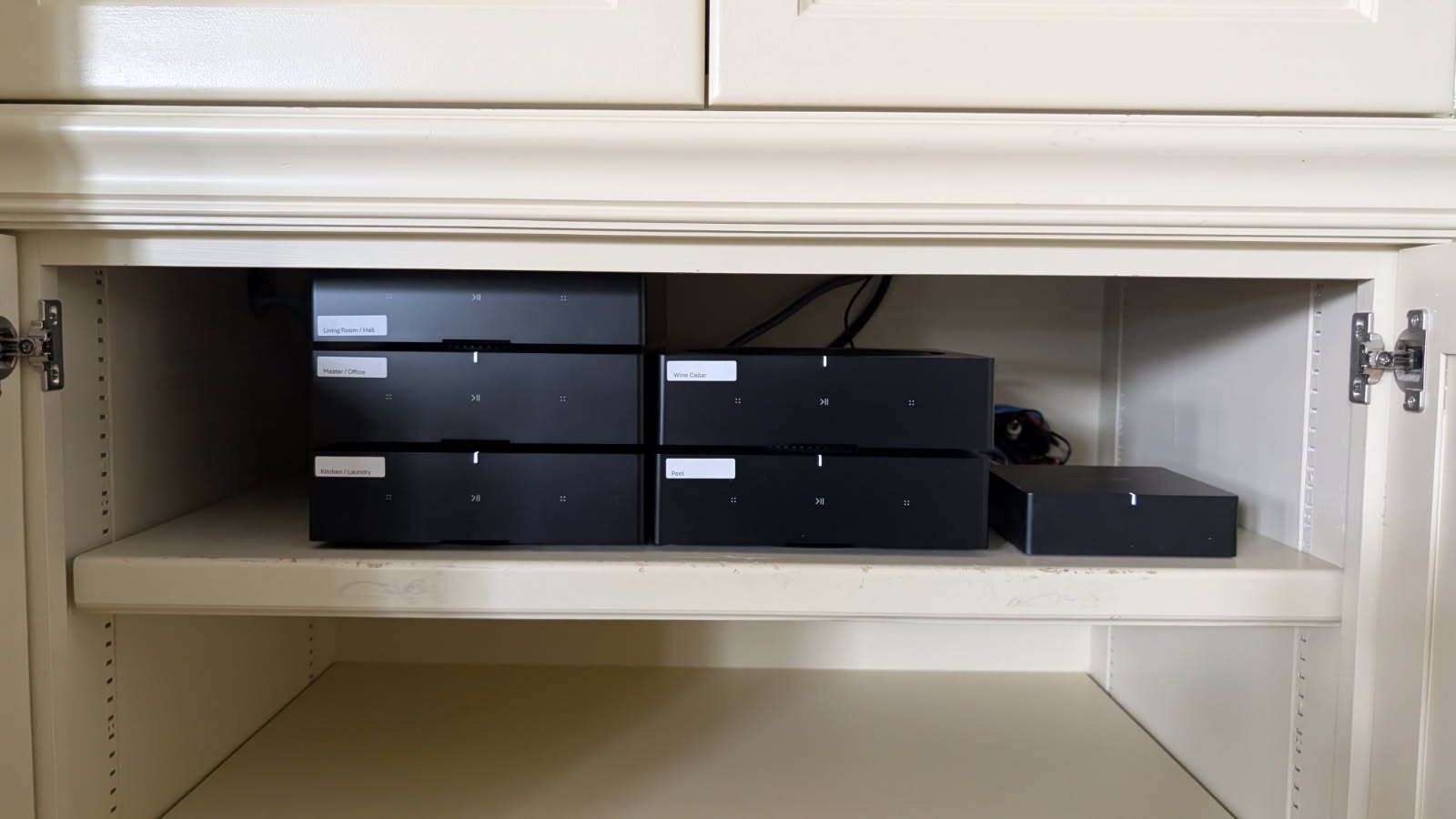 A row of black boxes are stacked on top of each other in a cabinet.