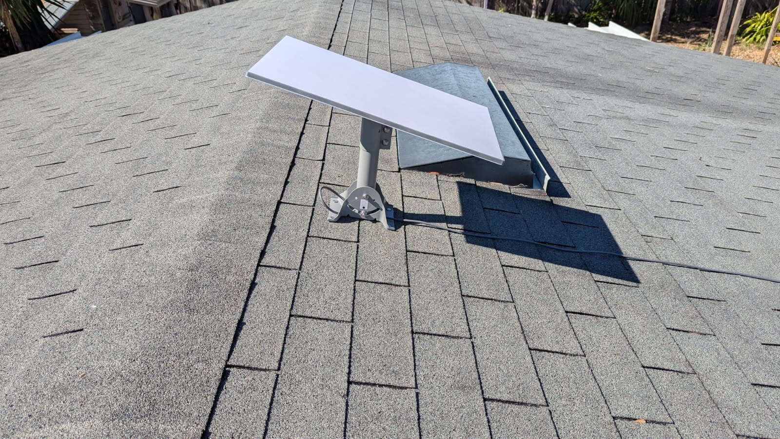 A satellite dish is sitting on top of a roof.