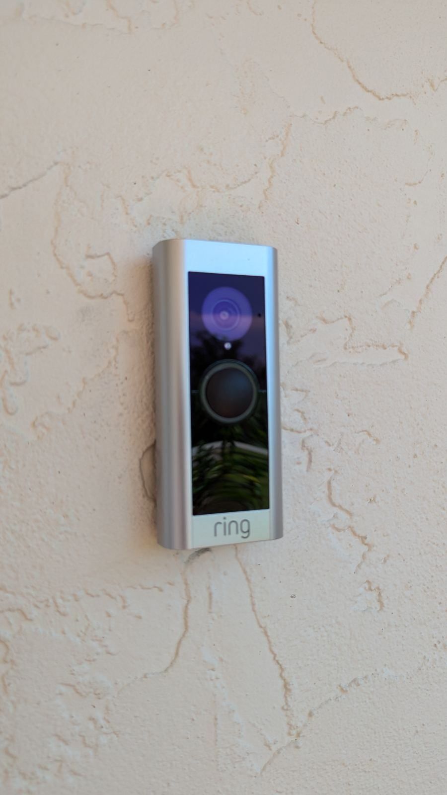A ring doorbell is mounted on a white wall.