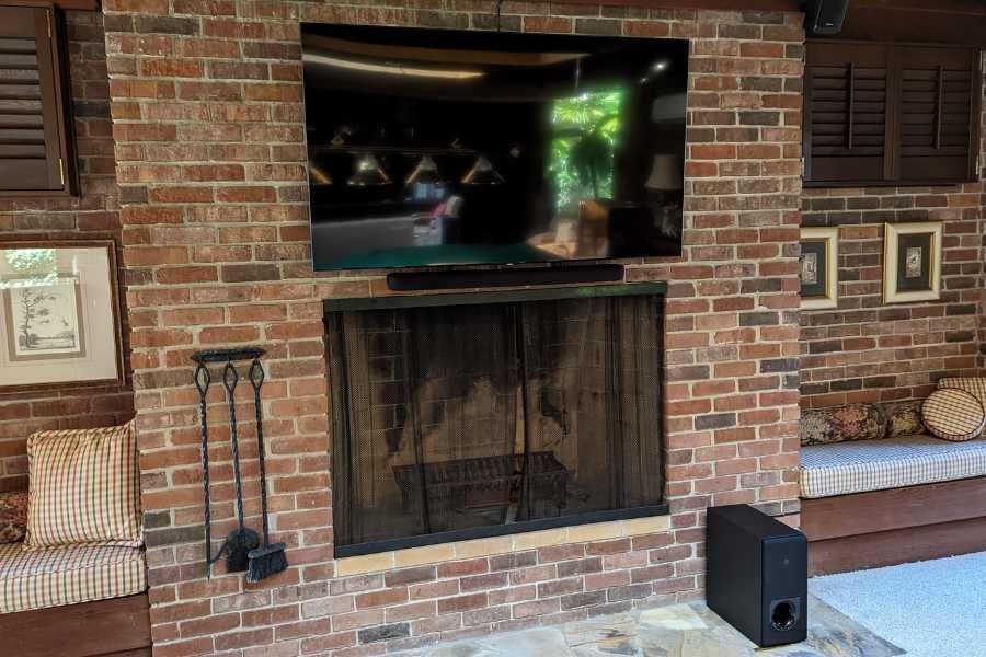 A living room with a fireplace and a flat screen tv mounted on the wall.