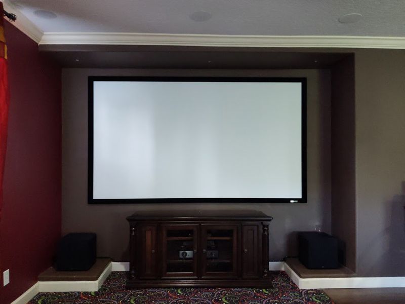 A home theater with a projector screen and speakers