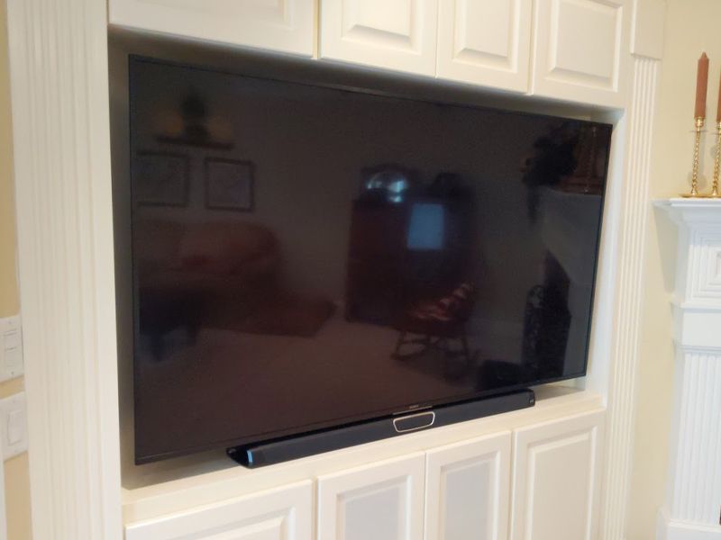 A flat screen tv is mounted on a wall in a living room.