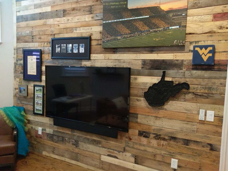 A living room with a wooden wall and a flat screen tv.