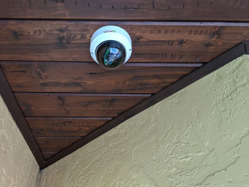 A security camera is hanging from the ceiling of a building.