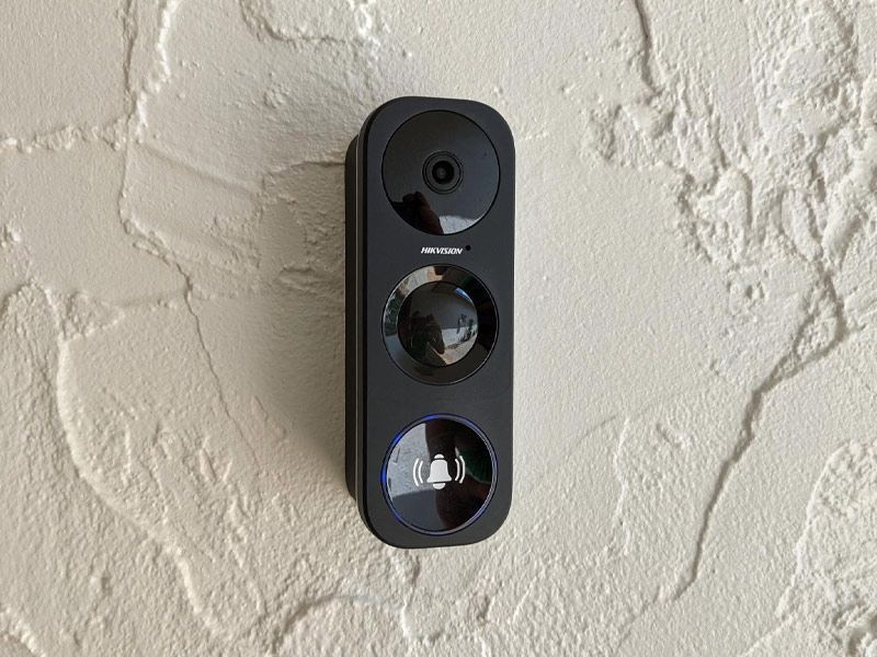 A black doorbell is mounted on a white wall.