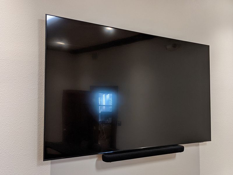 A large flat screen tv is mounted on a wall.