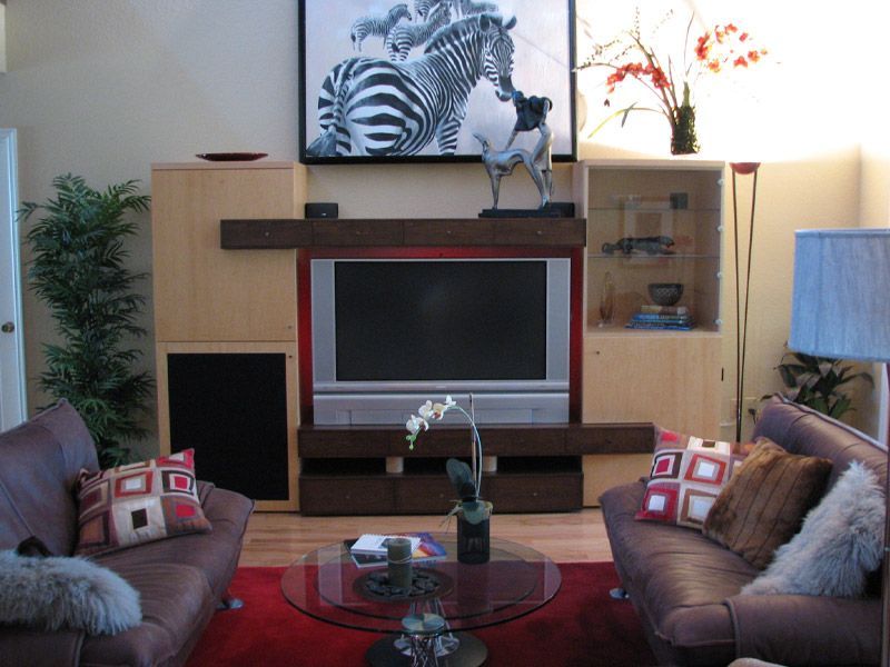 A living room with a zebra painting above the television
