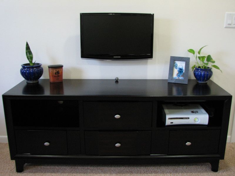 A black entertainment center with a xbox on it