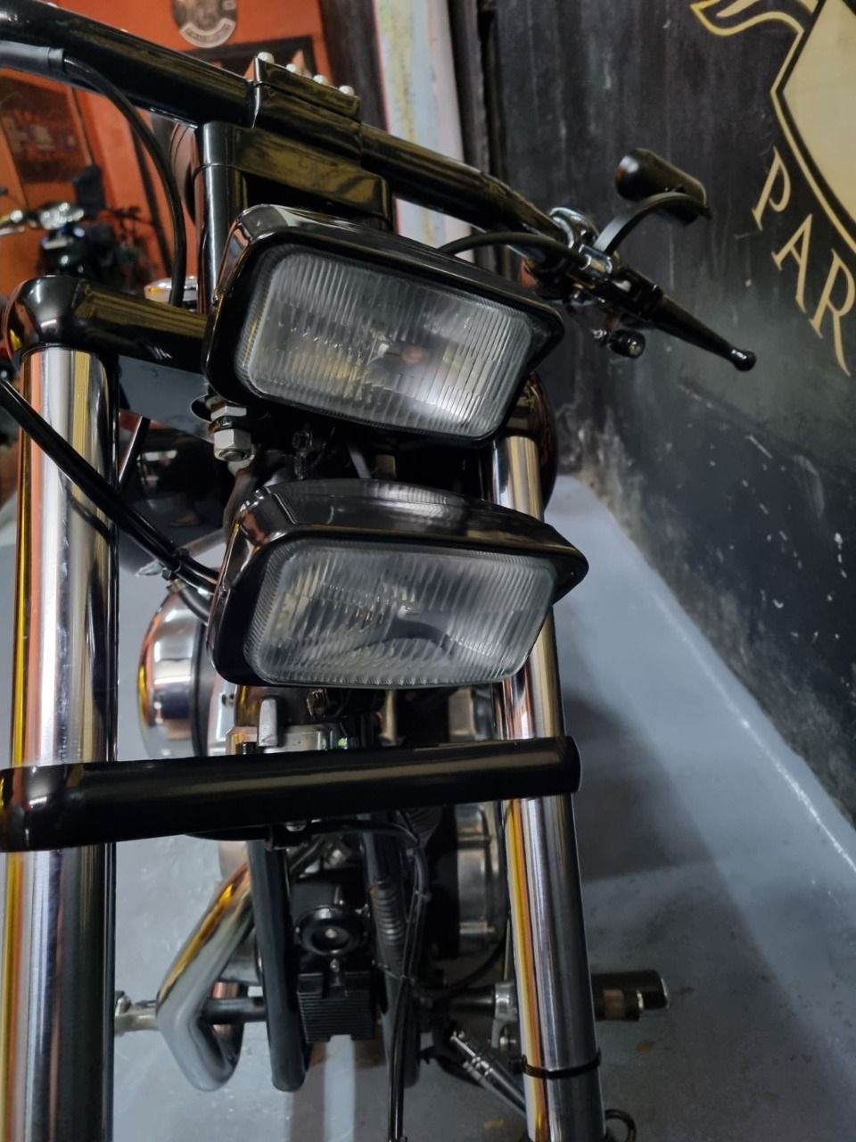 A motorcycle is parked in front of a sign that says par