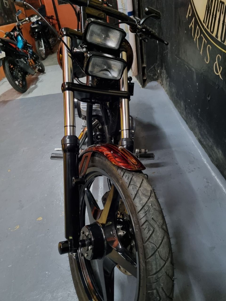 A motorcycle is parked in a garage next to a wall.