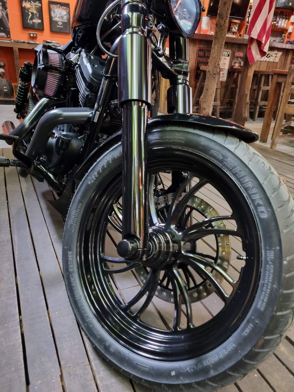 A close up of a motorcycle wheel on a wooden floor