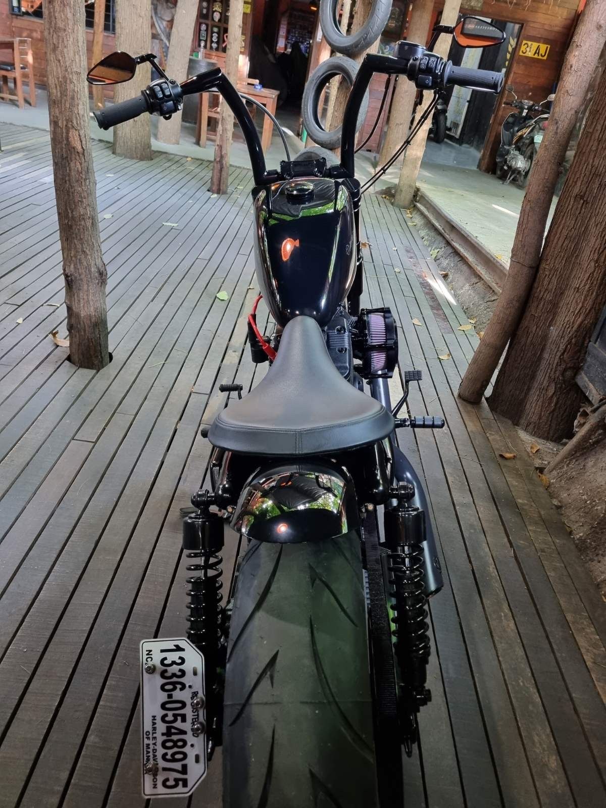 A black motorcycle is parked on a wooden deck.