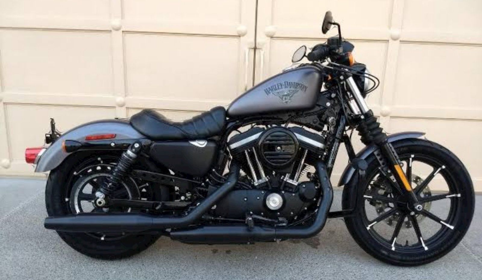 A motorcycle is parked in front of a garage door.