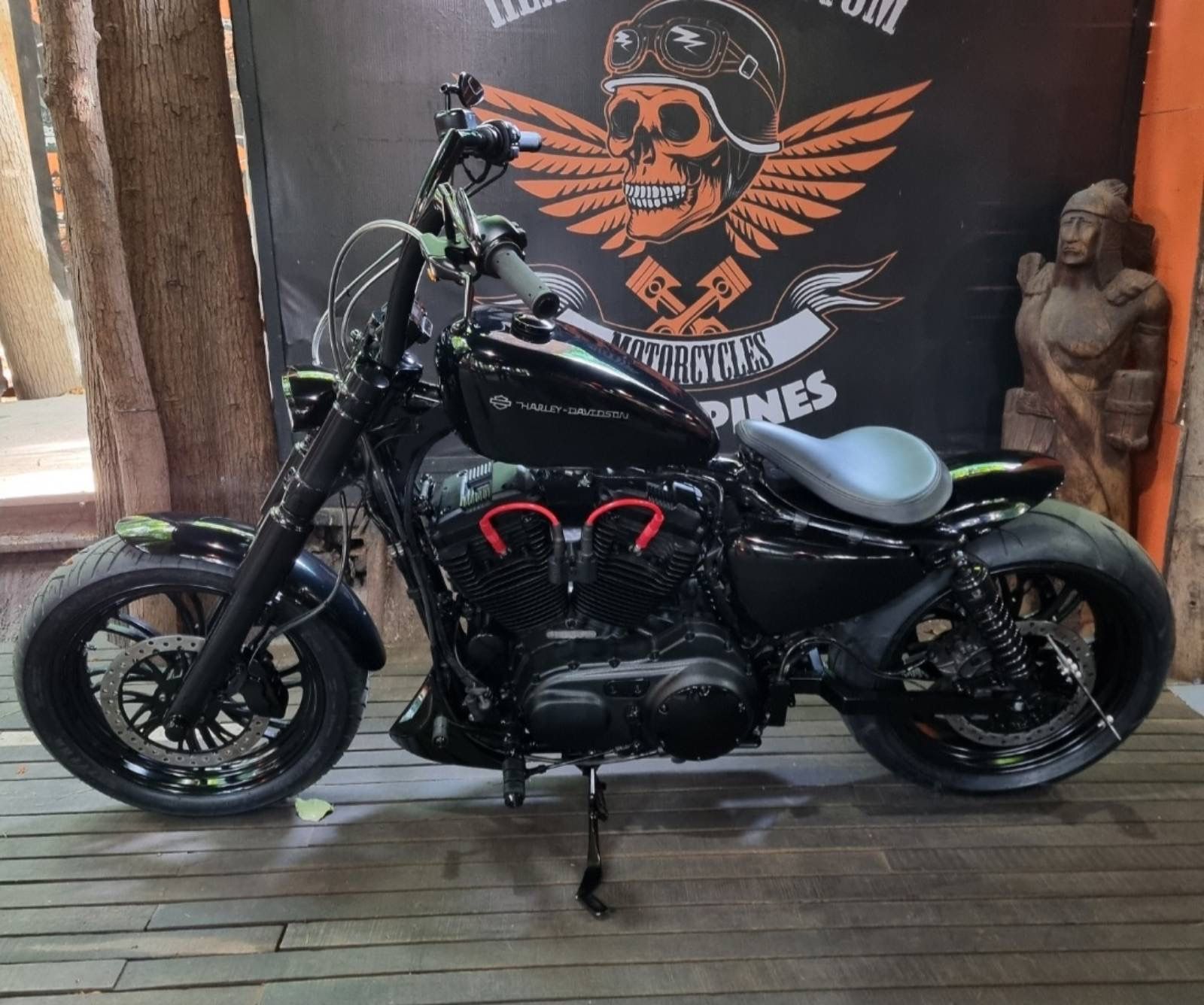 A motorcycle is parked in front of a sign that says motorcycles