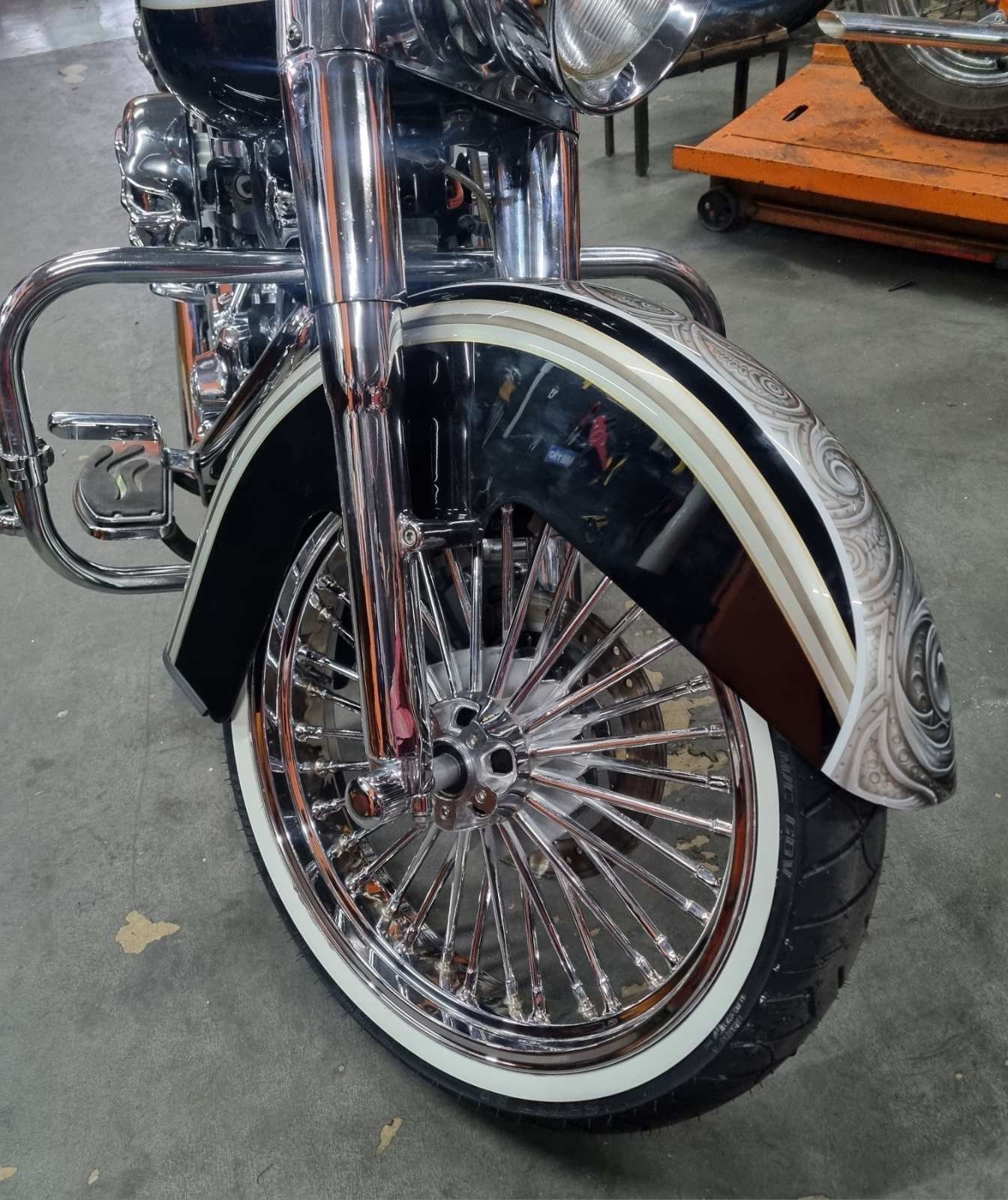 A motorcycle with chrome fenders and white tires