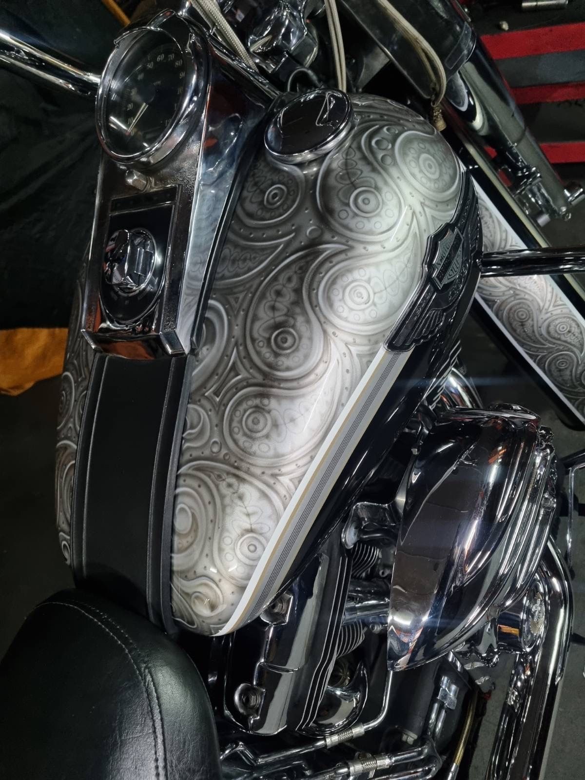 A close up of a motorcycle with a silver tank and a black seat.