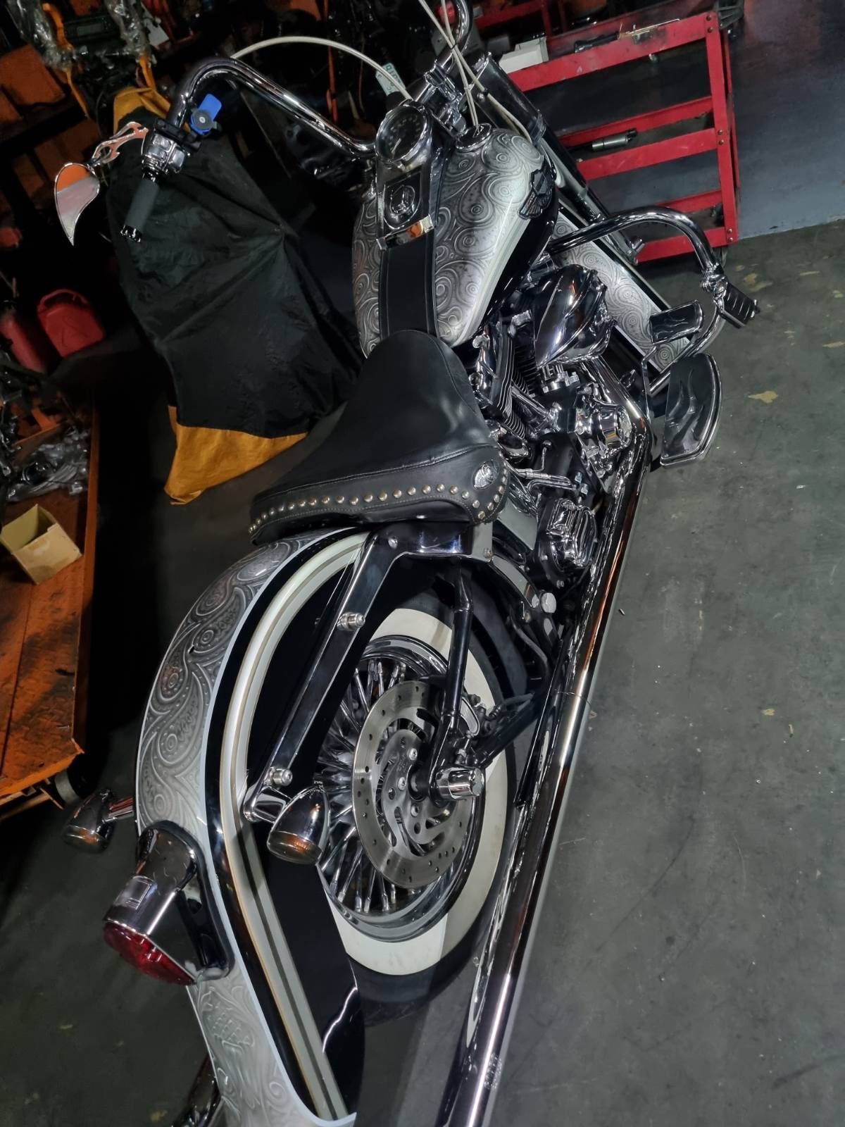 A black and silver motorcycle is parked in a garage.