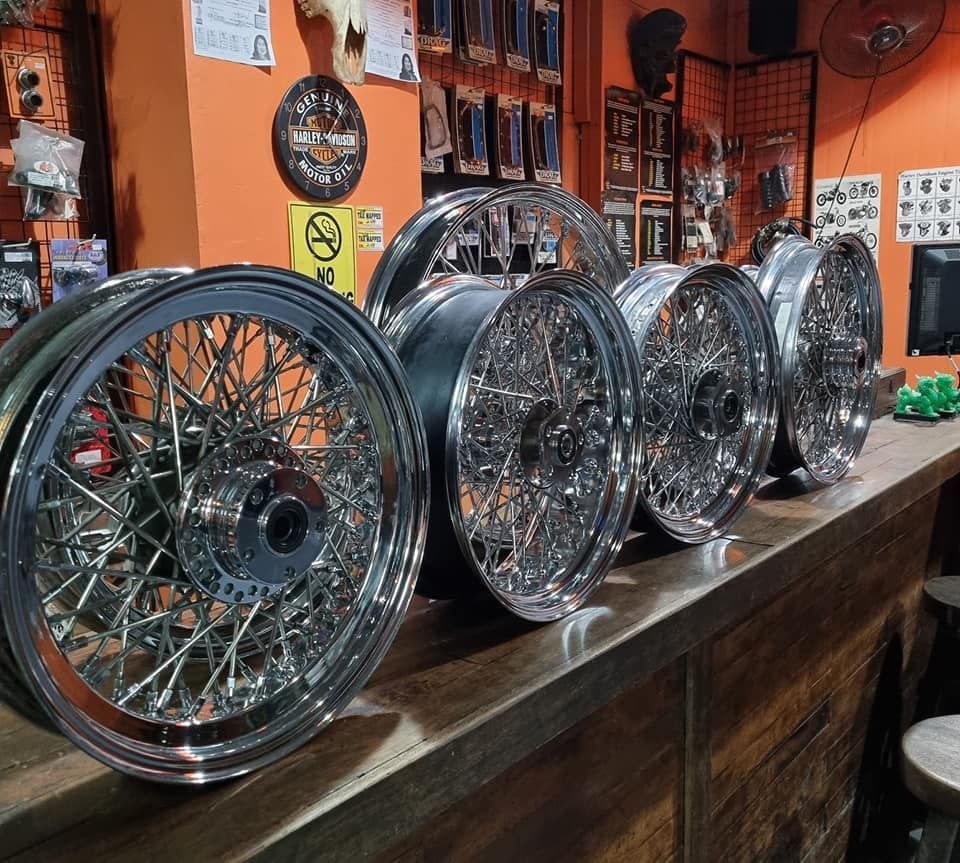 a row of chrome wheels are sitting on a wooden counter .