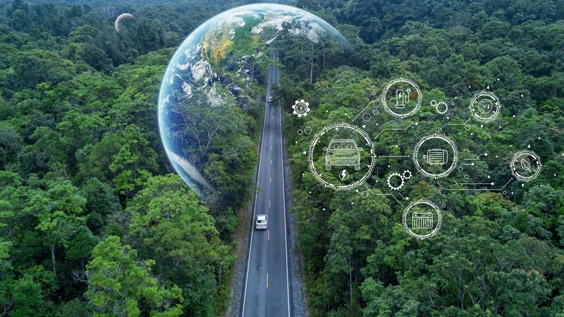 an aerial view of a road going through a forest with a globe in the background