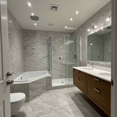 A bathroom with a tub , toilet , sink and mirror.