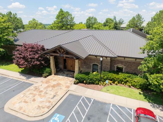 an aerial view of a house with a river in the background