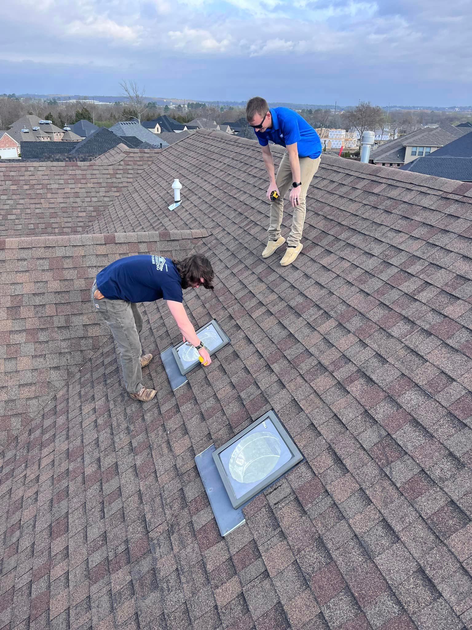 two men are working on the roof of a house