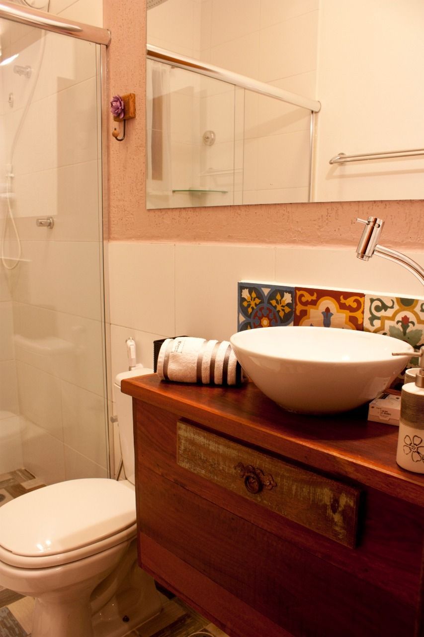 Um banheiro com vaso sanitário, pia e espelho