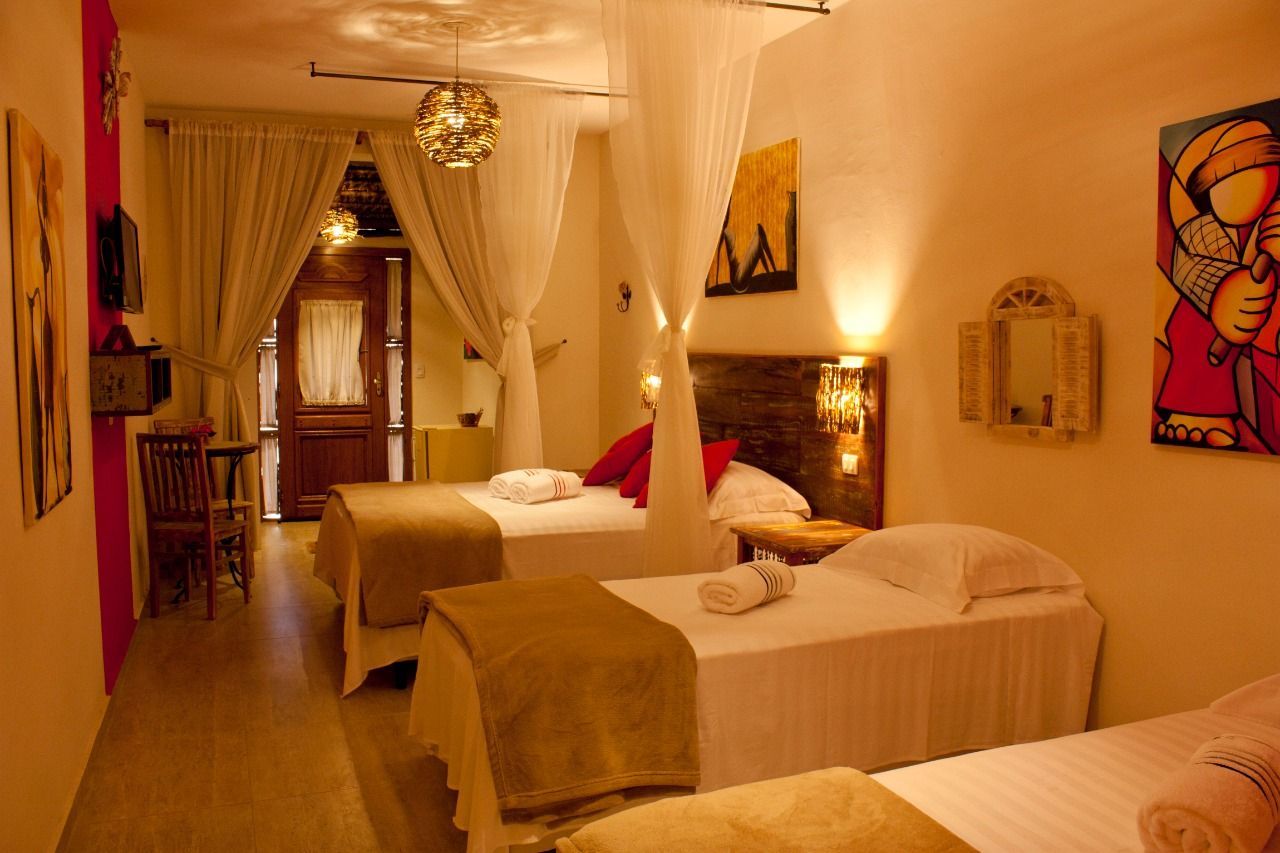 Um quarto de hotel com três camas e uma pintura na parede