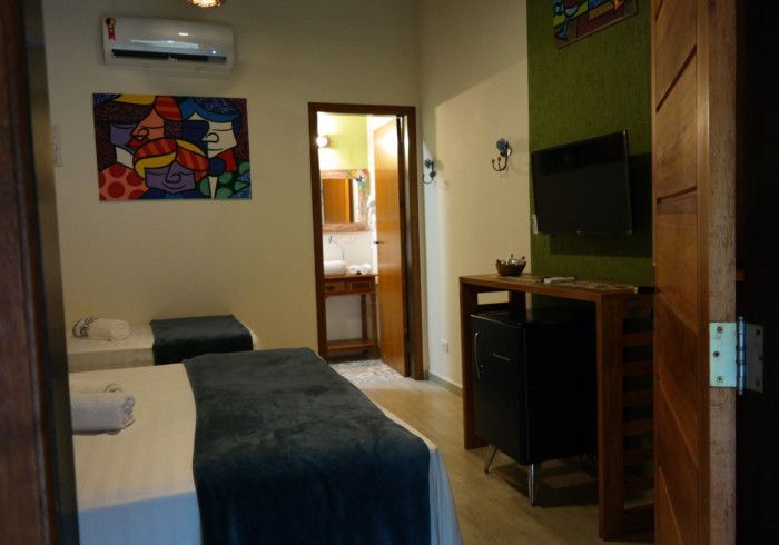 Um quarto de hotel com duas camas e uma televisão