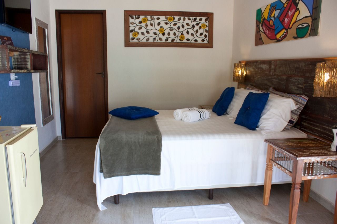 Um quarto com cama king size e travesseiros azuis