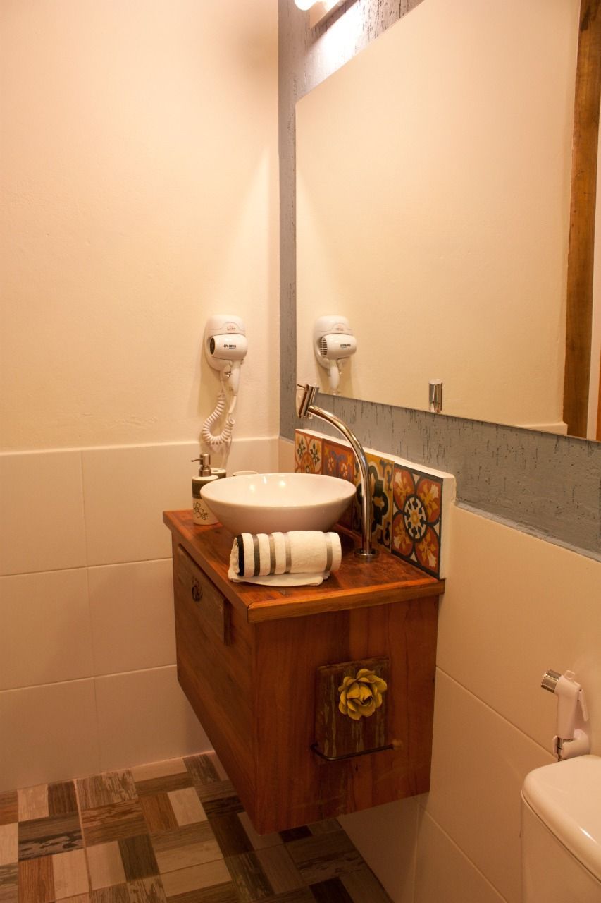 Um banheiro com pia, vaso sanitário e espelho.