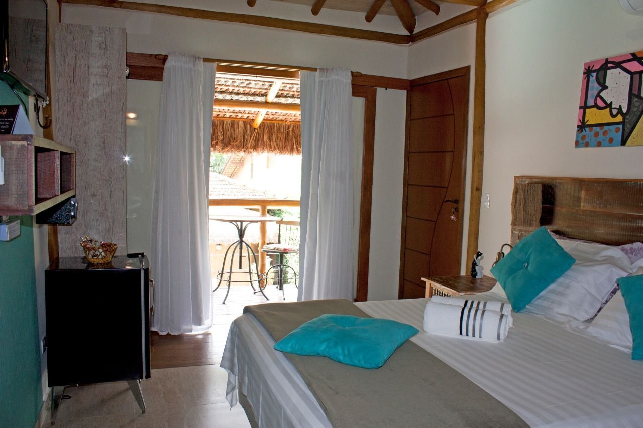 Um quarto com cama e varanda com mesa e cadeiras.