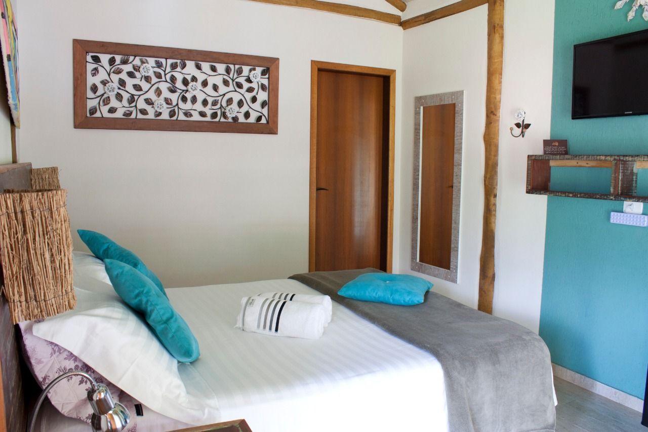 Um quarto com uma cama e uma televisão na parede.