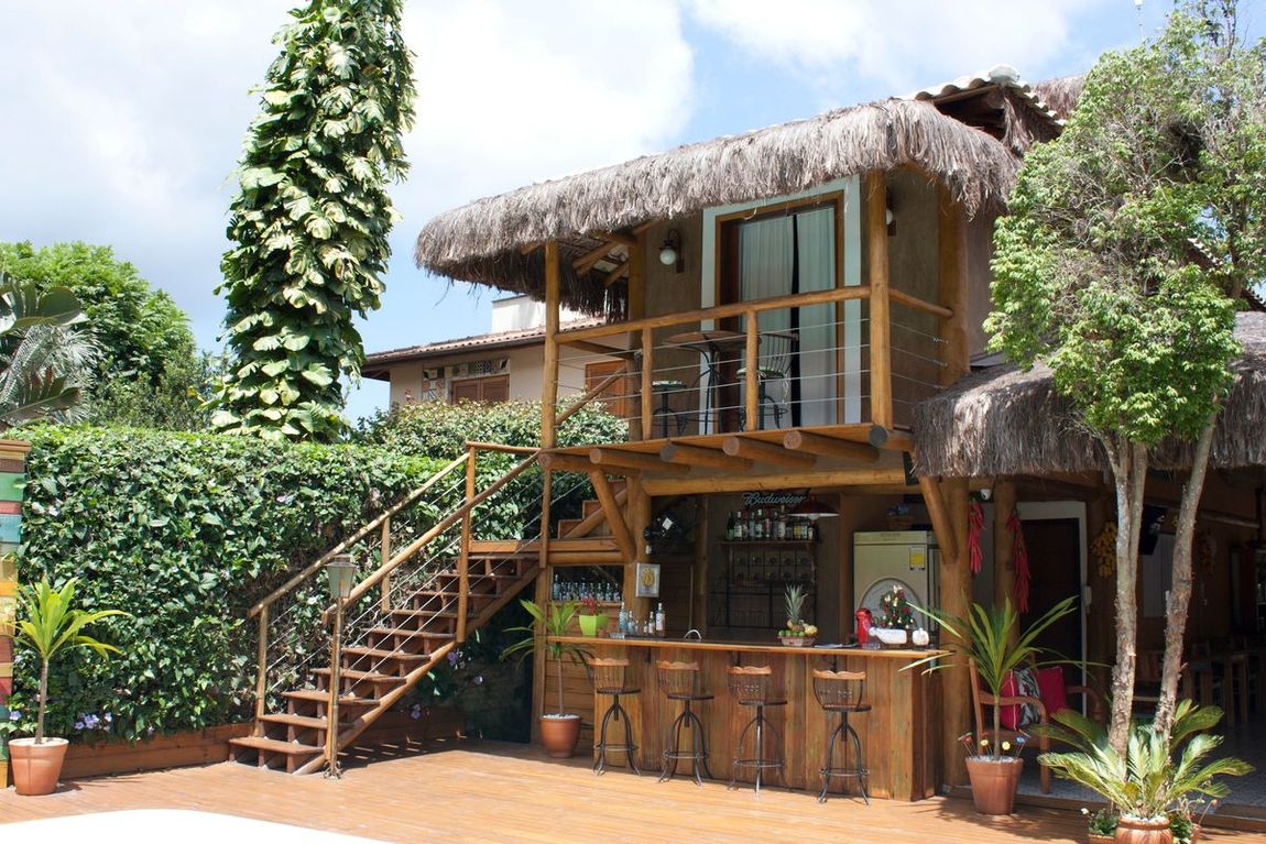 Uma casa de madeira com telhado de palha e escadas que levam até ela