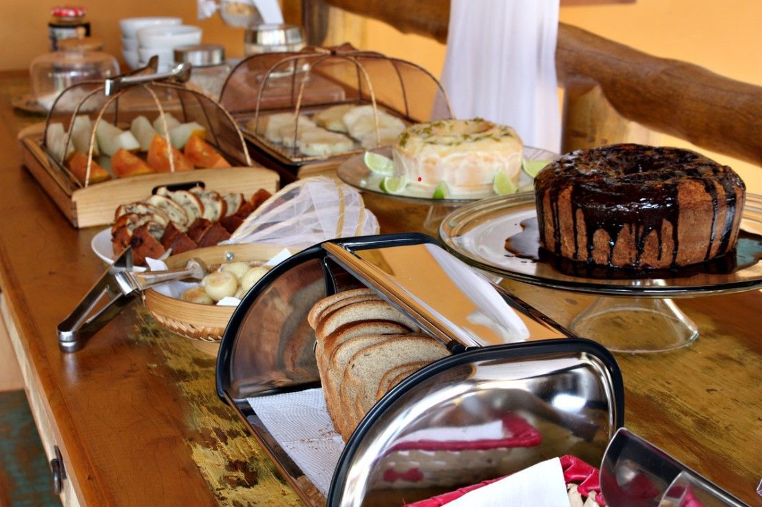 Uma mesa coberta com uma variedade de alimentos, incluindo pães e bolos.