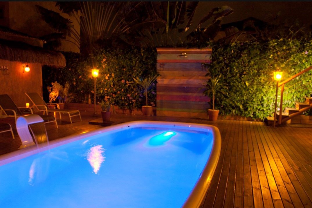 Uma grande piscina é iluminada à noite com luzes azuis.
