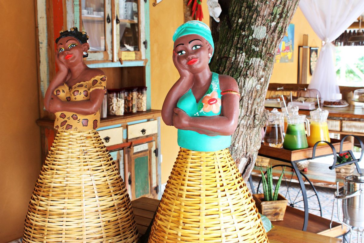 Duas estátuas de mulheres estão lado a lado em uma sala.