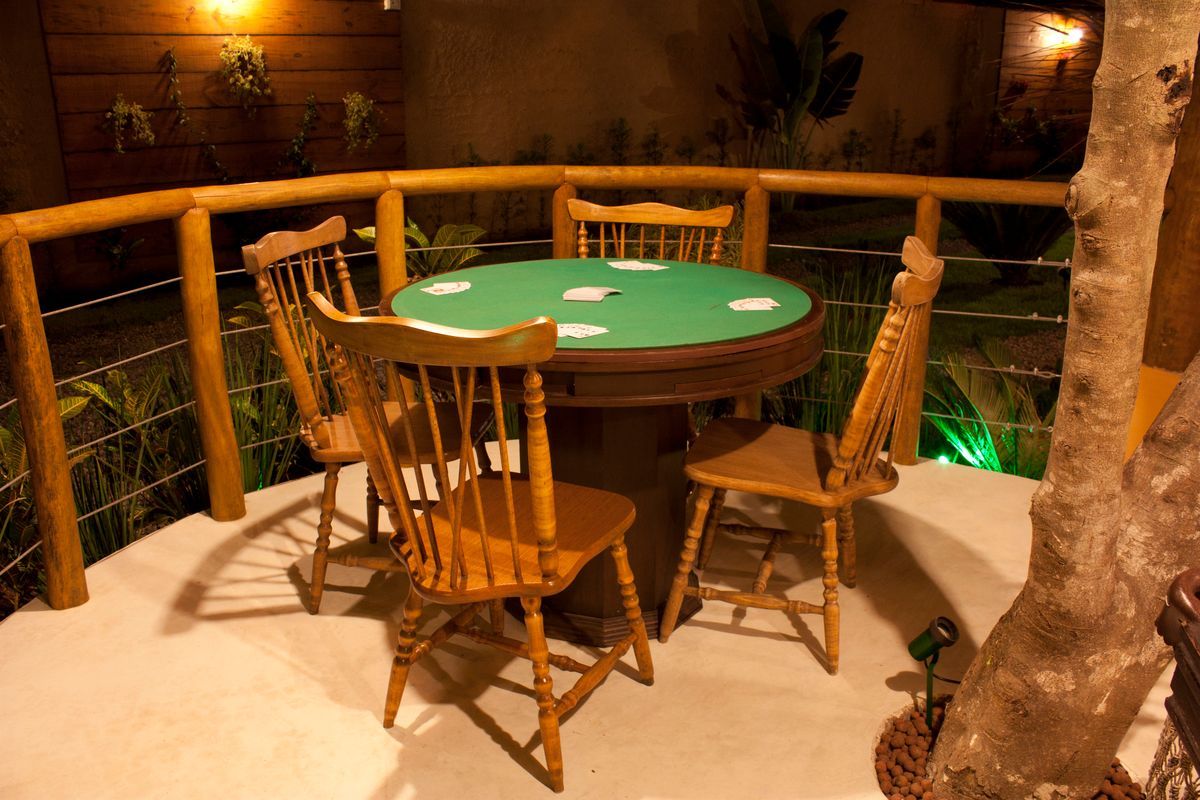 Uma mesa com uma toalha verde e quatro cadeiras